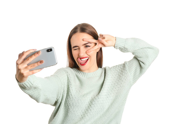 Bella giovane donna che prende selfie su sfondo bianco - Foto, immagini