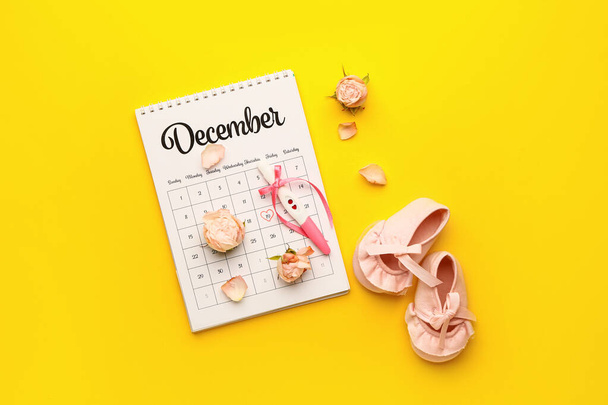 Těhotenský test, kalendář, květiny a dětské boty na barevném pozadí - Fotografie, Obrázek