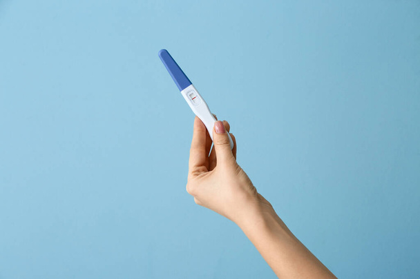 Female hand with pregnancy test on color background - 写真・画像