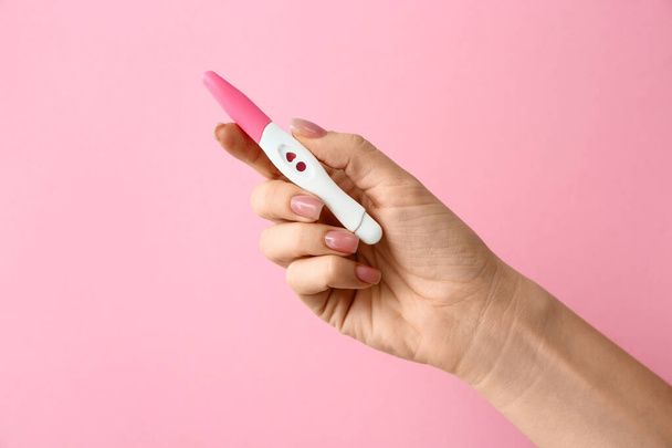 Renk arka plan üzerinde gebelik testi ile kadın el - Fotoğraf, Görsel
