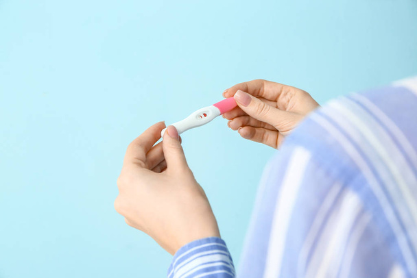 Young woman with pregnancy test on color background - Fotografie, Obrázek