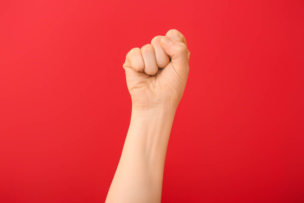Hand of woman with clenched fist on color background - Foto, imagen