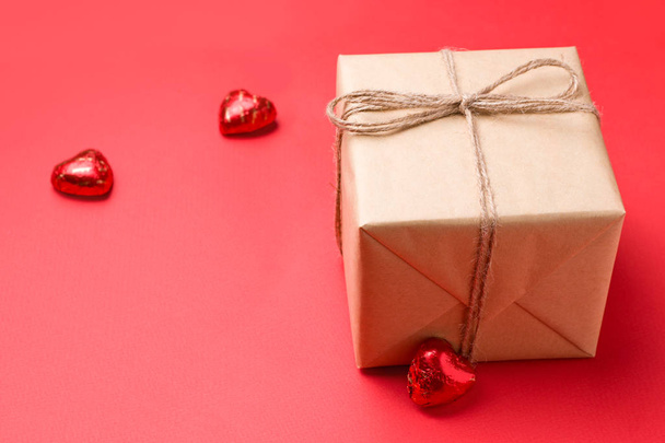 Valentine's Day gifts on red background next to chocolate candies in heart shape closeup. copy space - Foto, Imagem