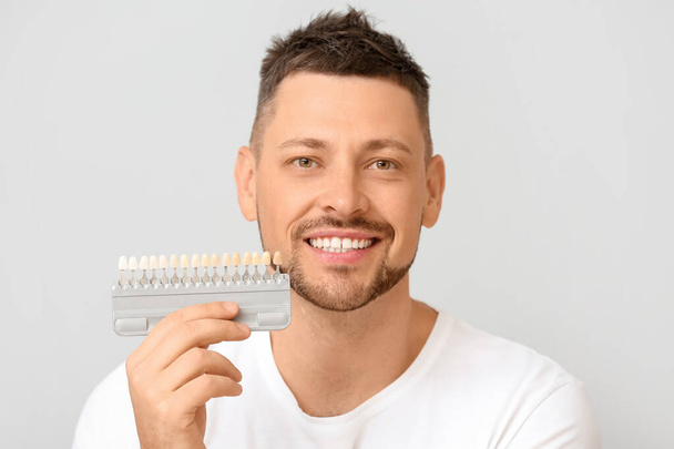 Uomo con i denti campioni di colore su sfondo chiaro
 - Foto, immagini