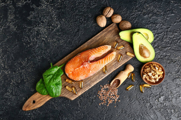 Joukko terveellisiä tuotteita korkea omega 3 ja kalaöljy pillereitä tummalla pohjalla
 - Valokuva, kuva
