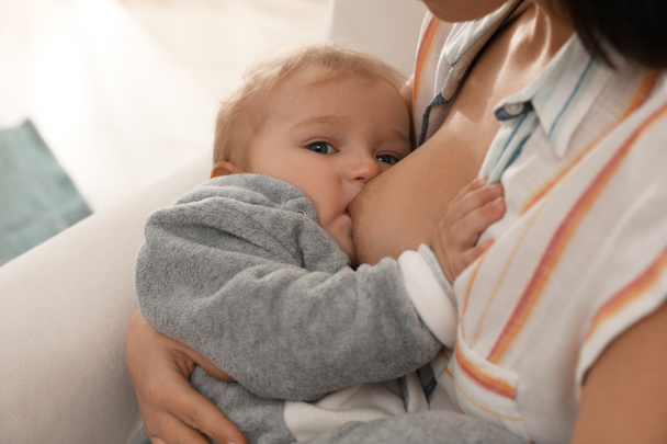 Mujer amamantando a su pequeño bebé en casa, primer plano
 - Foto, Imagen