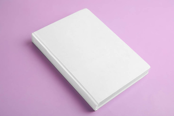 Book with blank cover on violet background - Foto, imagen