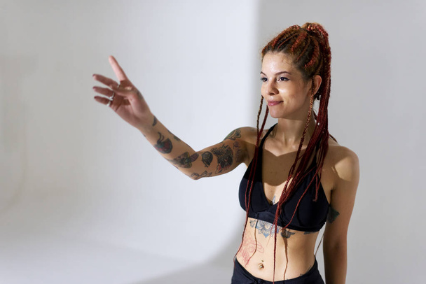 Black dressed and braided hair woman with tattoos dancing on a w - Foto, Imagem