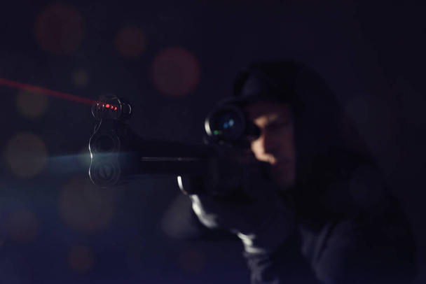 Professional killer on black background, focus on sniper rifle - 写真・画像
