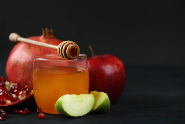 Honing, appels en granaatappel op donker houten tafel, close-up. Rosh Hashanah vakantie - Foto, afbeelding