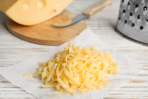 Tasty grated cheese on white wooden table - 写真・画像
