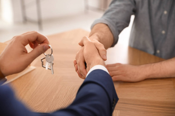 Immobilienmakler beim Händeschütteln mit Klient im Büro, Nahaufnahme - Foto, Bild
