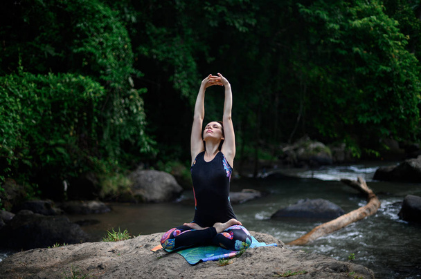 Yoga beoefening en meditatie in de natuur. Vrouw in de buurt van rivier - Foto, afbeelding