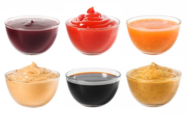 Veel verschillende sauzen in een glazen schaal op een witte achtergrond  - Foto, afbeelding