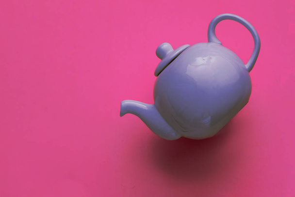 blue porcelain teapot on a pink background, minimal art, close-up, flat lay - Foto, Bild