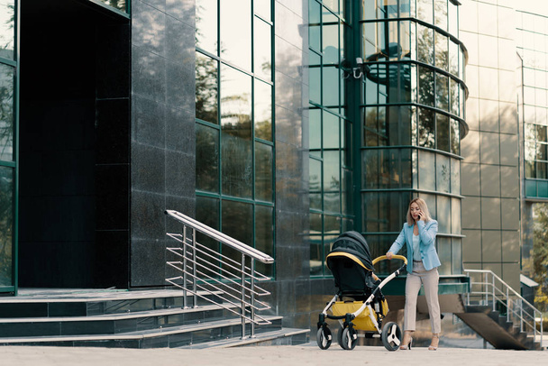 Retrato de una exitosa mujer de negocios en traje azul con bebé
 - Foto, Imagen