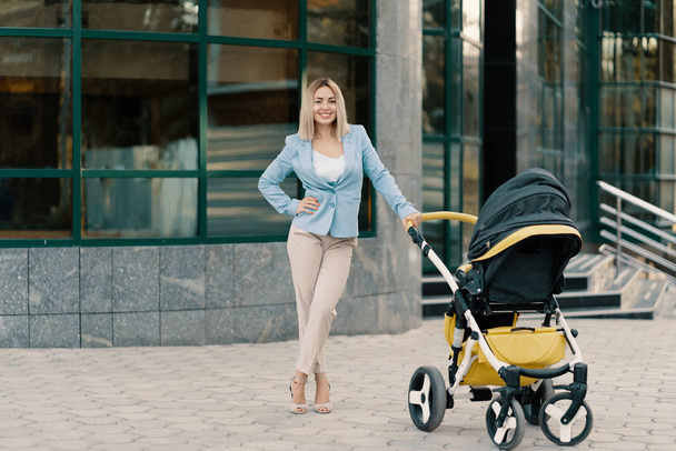 Porträt einer erfolgreichen Geschäftsfrau im blauen Anzug mit Baby - Foto, Bild