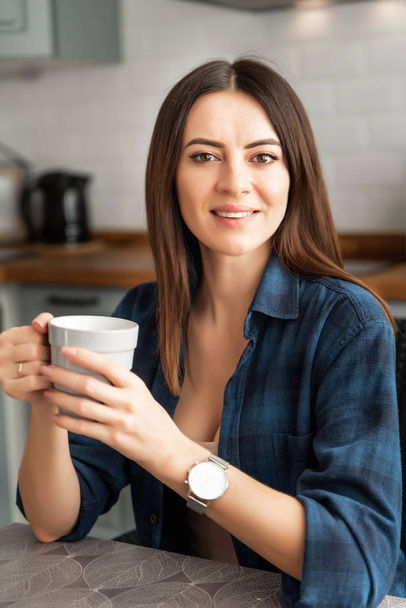 Girl in a shirt with coffee in hand. - Fotoğraf, Görsel