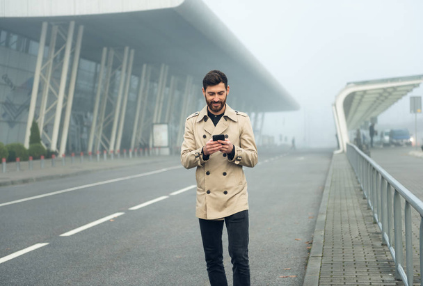 Businessman texting messages while walking. - Фото, зображення