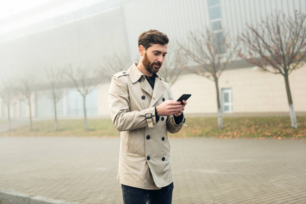 Businessman texting messages while walking. - Fotografie, Obrázek
