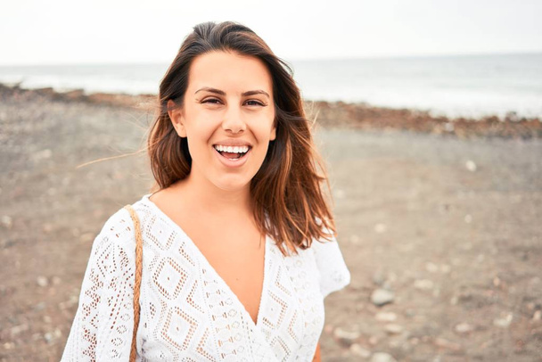 Jovem mulher bonita sorrindo feliz desfrutando de férias de verão na praia de areia preta em Ilhas Canárias
 - Foto, Imagem