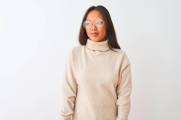 Young chinese woman wearing turtleneck sweater and glasses over isolated white background smiling looking to the side and staring away thinking. - Photo, image