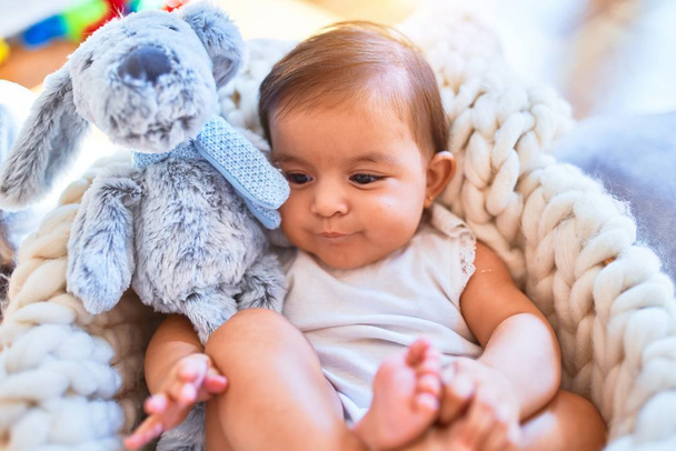Gyönyörű csecsemő boldog az óvodában körül színes játékok feküdt benne bölcső - Fotó, kép