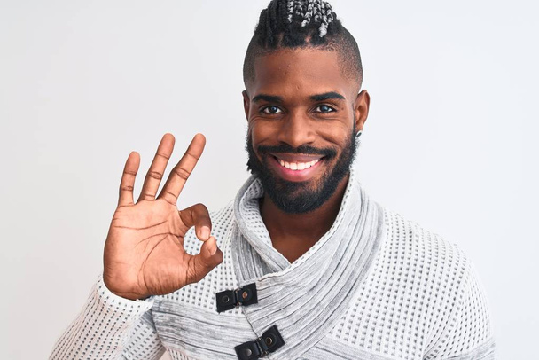 Африканский американец с косичками в сером свитере на изолированном белом фоне делает хорошо знак с пальцами, отличный символ
 - Фото, изображение