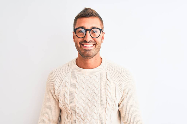 Fiatal jóképű férfi szemüveget visel és téli pulóvert elszigetelt háttér egy boldog arc áll és mosolyog magabiztos mosollyal mutatja fogak - Fotó, kép