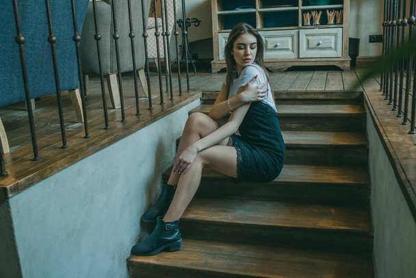 Beautiful elegant brunette girl wearing a black dress is relaxing in a street cafe. Advertising, fashion. Tinted photo - Zdjęcie, obraz
