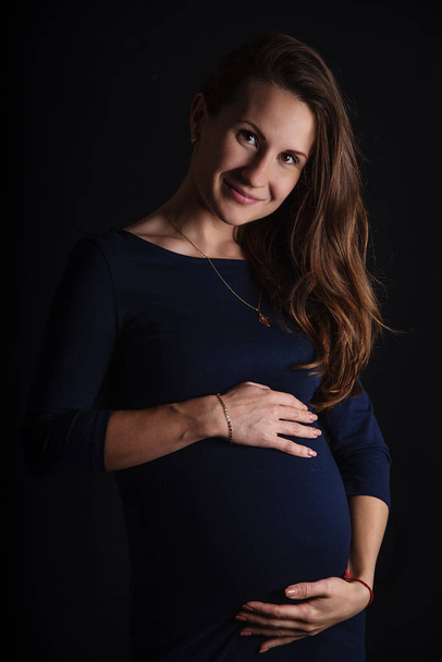 A pregnant woman hugs her belly with love. - Photo, Image