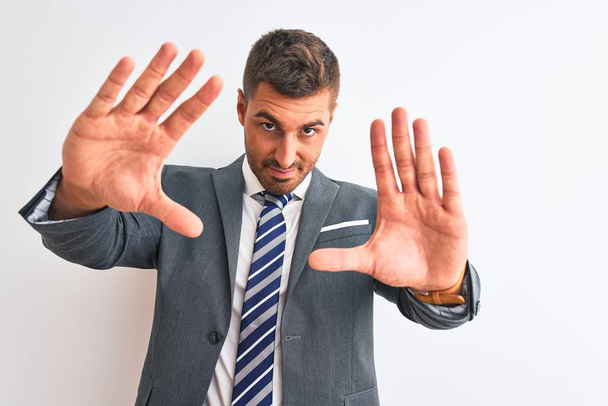 Young handsome business man wearing suit and tie over isolated background doing frame using hands palms and fingers, camera perspective - Photo, image