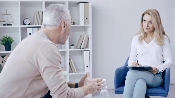 зрілий чоловік жестикулює під час розмови з уважним психологом
 - Кадри, відео