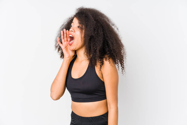 Молода афроамериканська спортивна жінка кричить і тримаючи пальму біля відкритого рота.. - Фото, зображення