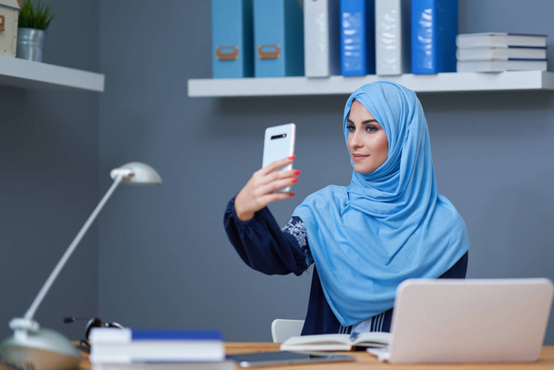 Erwachsene muslimische Frau nutzt Smartphone - Foto, Bild