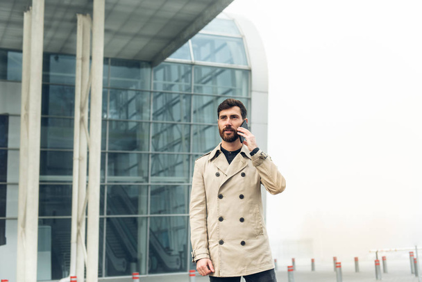 Businessman on the airport holding mobile phone. - Photo, Image