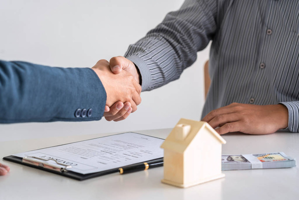 Агент по недвижимости пожимает руку после хорошей сделки и дает h
 - Фото, изображение