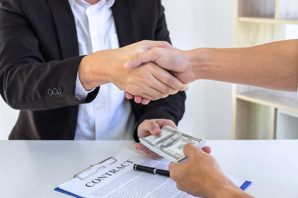 Businessman handshake with money of dollar banknotes in hands fr - Фото, изображение