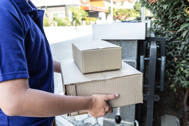 Young Delivery man leveren doos pakket en verzenden naar cus - Foto, afbeelding