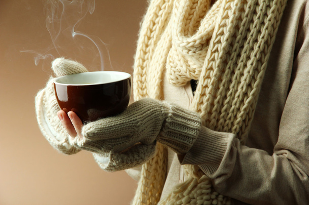 Female hands with hot drink, on color background - Valokuva, kuva