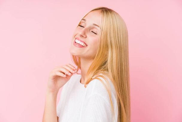 jong blond vrouw gezicht closeup geïsoleerd op een roze achtergrond - Foto, afbeelding