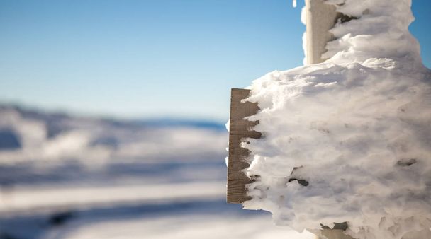 A placa de cerca de madeira mostra-se lentamente sob a neve. É uma beleza.
 - Foto, Imagem