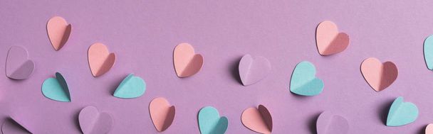 Menekşe arkaplanda renkli kağıt kalplerin üst görünümü, panoramik çekim - Fotoğraf, Görsel