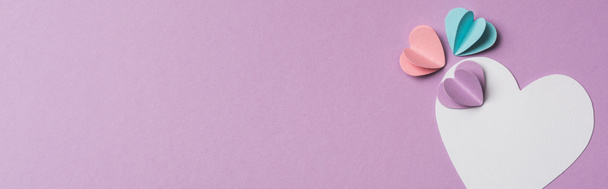 Menekşe arkaplan üzerinde renkli kağıt kalpler olan boş kartın üst görünümü, panoramik çekim - Fotoğraf, Görsel