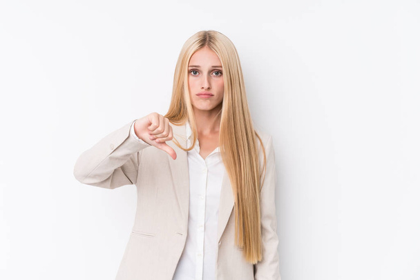Jonge zakelijke blonde vrouw op witte achtergrond toont een afkeer gebaar, duimen naar beneden. Concept van onenigheid. - Foto, afbeelding