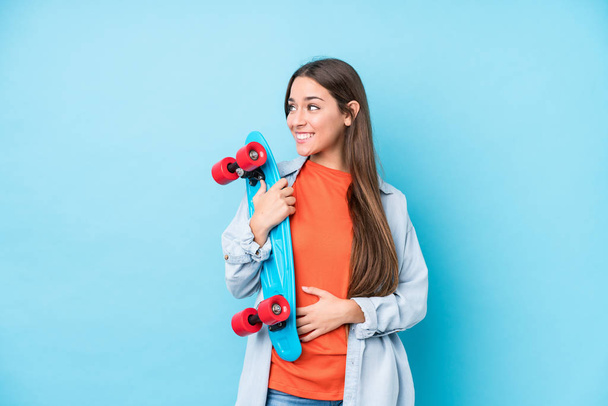 Young caucasian skater woman isolated on blue background - Photo, Image