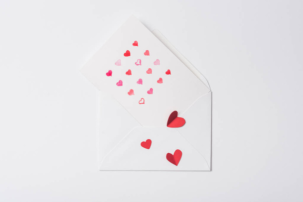 vue du haut de la carte de vœux de Saint-Valentin dans une enveloppe avec des cœurs rouges sur fond blanc
 - Photo, image