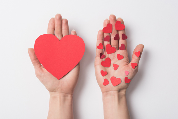 cropped view of woman holding red hearts on white background - 写真・画像