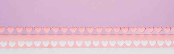 top view of pink, violet paper with cut out hearts on white background, panoramic shot - Foto, Imagem