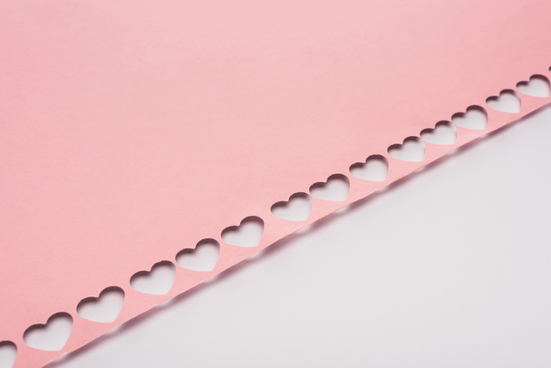 pink paper with cut out hearts on white background - Foto, Imagem